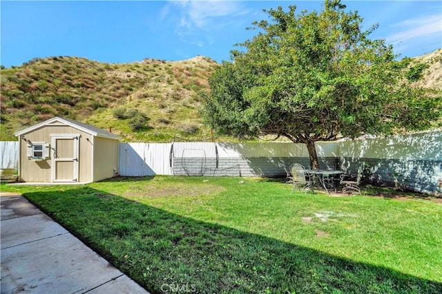 view of yard featuring an outbuilding, a shed, and a fenced backyard