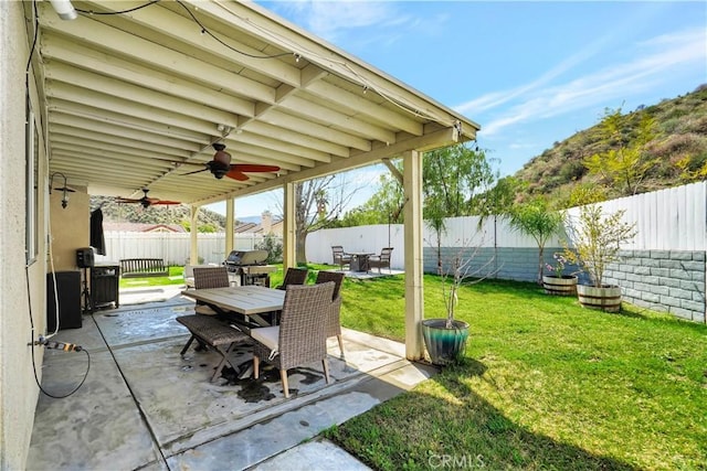 view of patio featuring a fenced backyard, outdoor dining space, ceiling fan, and area for grilling