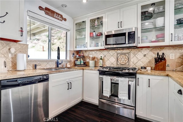 kitchen featuring dark wood-style flooring, appliances with stainless steel finishes, white cabinetry, and a sink