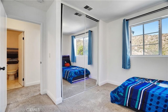 bedroom with baseboards, a closet, carpet floors, and visible vents