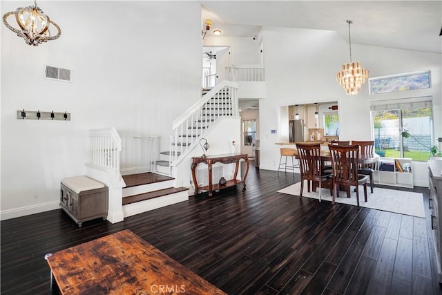 dining room with a notable chandelier, stairs, and wood finished floors