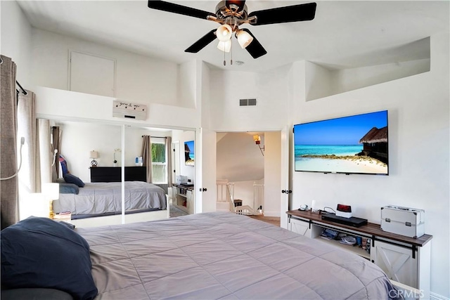 bedroom featuring visible vents, a ceiling fan, and a towering ceiling