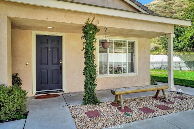 property entrance featuring fence and stucco siding