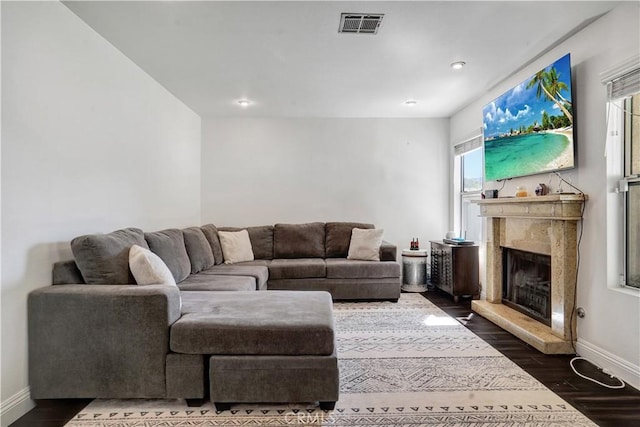 living area with visible vents, wood finished floors, a high end fireplace, recessed lighting, and baseboards