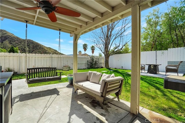 view of patio / terrace featuring a fenced backyard, a mountain view, ceiling fan, and outdoor lounge area