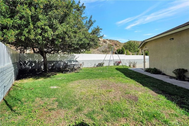 view of yard featuring a mountain view and a fenced backyard