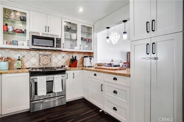 kitchen featuring decorative backsplash, appliances with stainless steel finishes, dark wood-style flooring, and white cabinetry