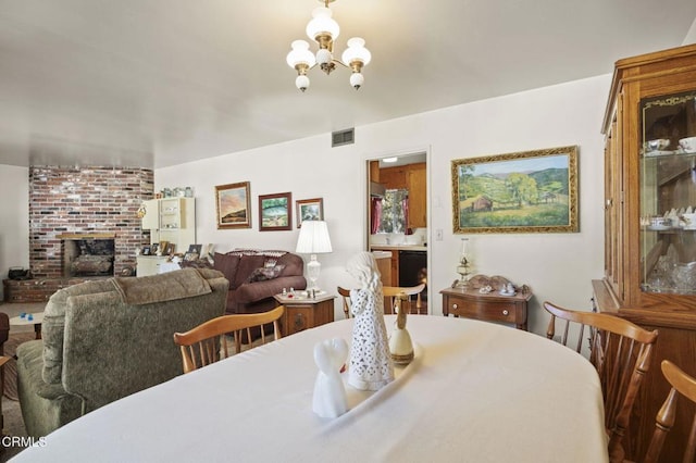 dining area featuring a brick fireplace, a notable chandelier, and visible vents