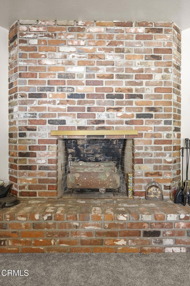 interior details featuring a brick fireplace