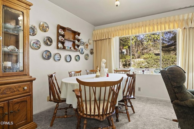 carpeted dining space featuring baseboards