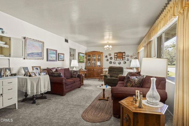 living area featuring a chandelier, visible vents, and carpet