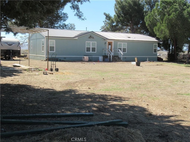 rear view of property featuring crawl space and metal roof