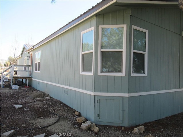 view of side of home with crawl space and metal roof