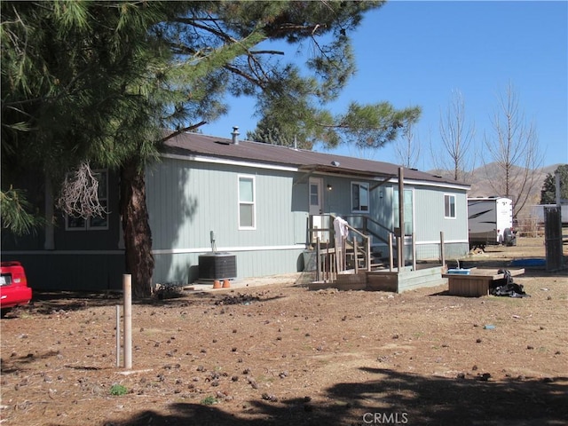 rear view of property featuring central AC