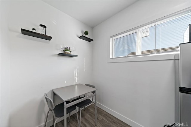 dining space featuring baseboards and wood finished floors