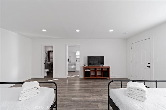 bedroom with recessed lighting, baseboards, dark wood-style floors, and stainless steel fridge with ice dispenser