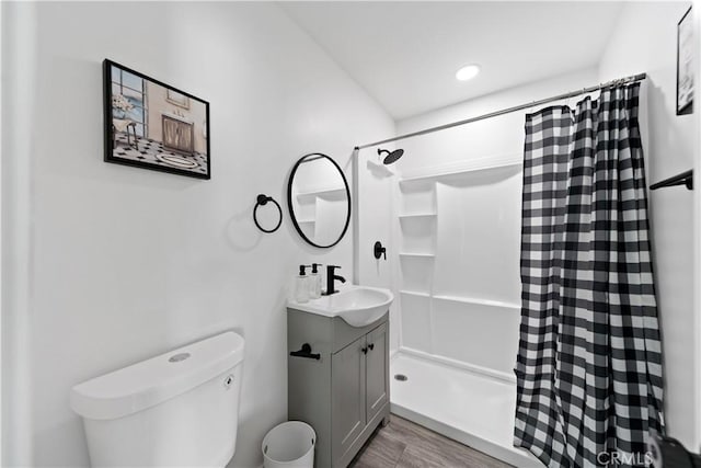 bathroom with vanity, toilet, a shower with curtain, and wood finished floors