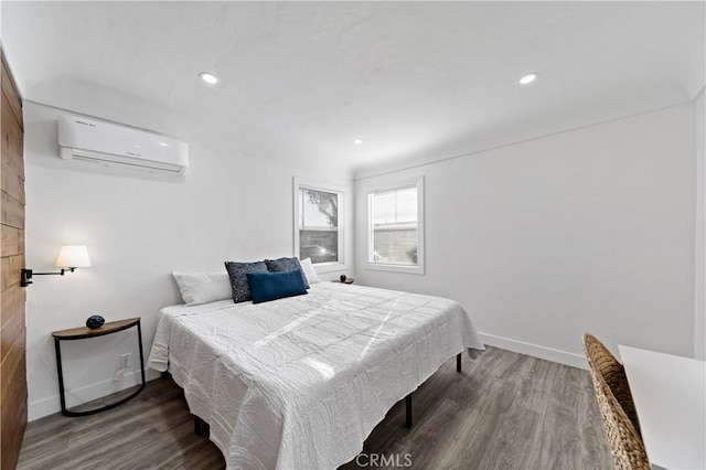 bedroom featuring recessed lighting, baseboards, wood finished floors, and a wall mounted AC