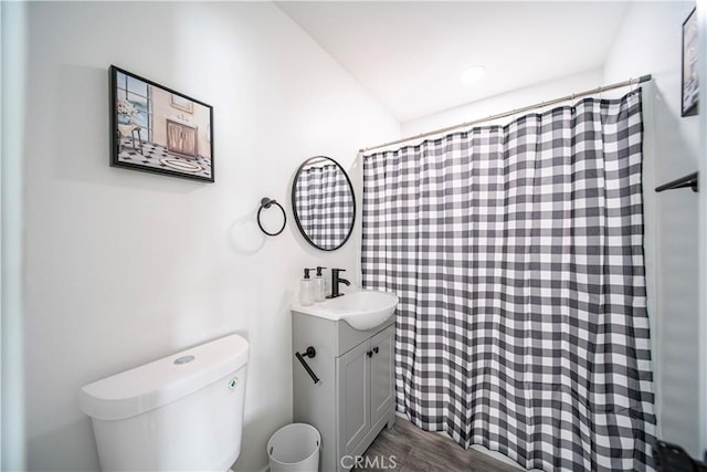 full bath featuring a shower with curtain, toilet, wood finished floors, and vanity