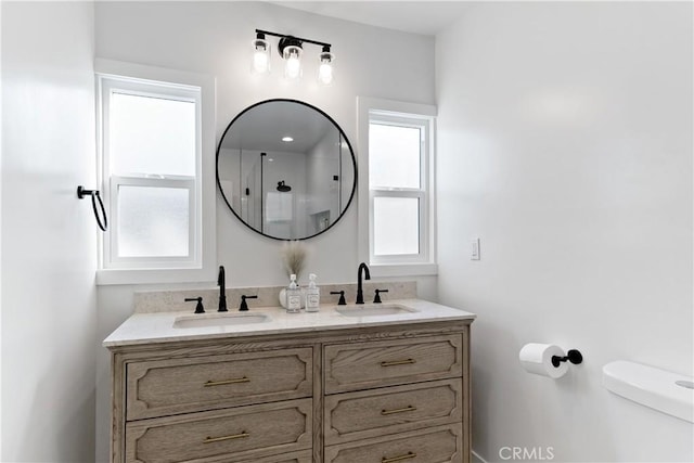 full bathroom with double vanity, toilet, a shower, and a sink