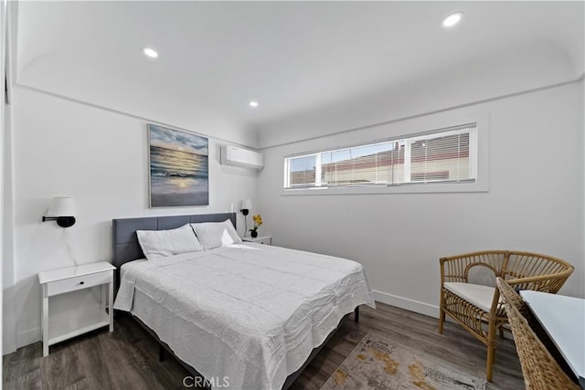 bedroom with recessed lighting, baseboards, a wall unit AC, and wood finished floors