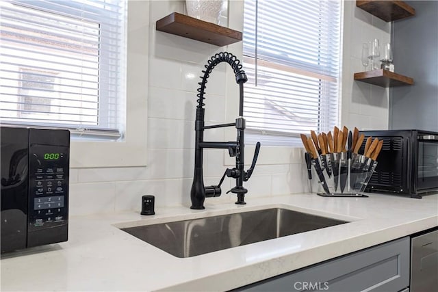 kitchen featuring open shelves, a wealth of natural light, and a sink