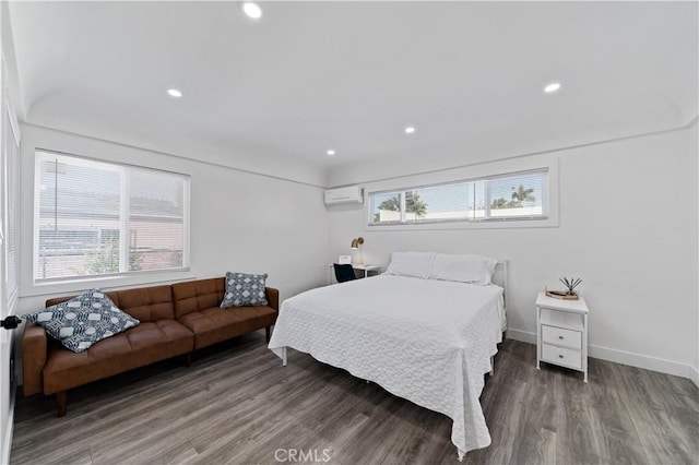 bedroom with recessed lighting, an AC wall unit, baseboards, and wood finished floors