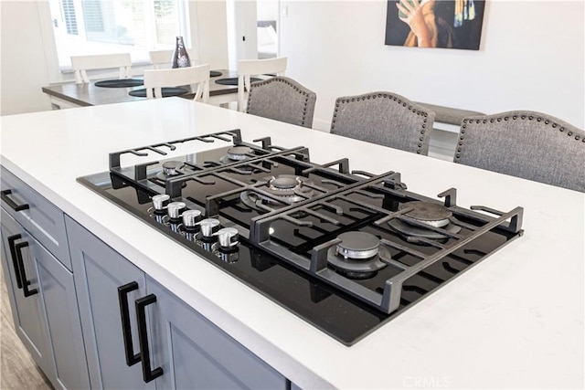 details featuring gray cabinetry, light countertops, and black gas stovetop