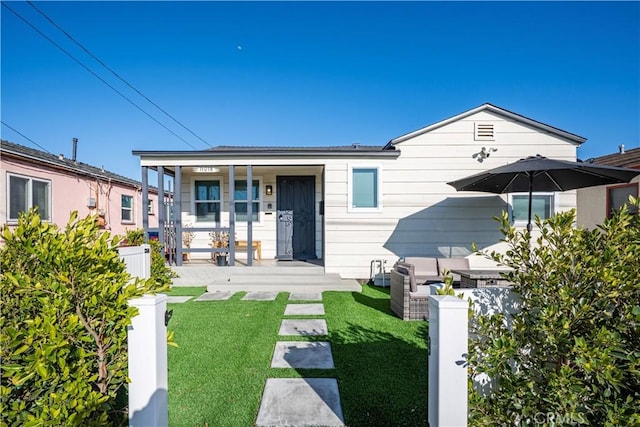 view of front of property with a porch and a front lawn