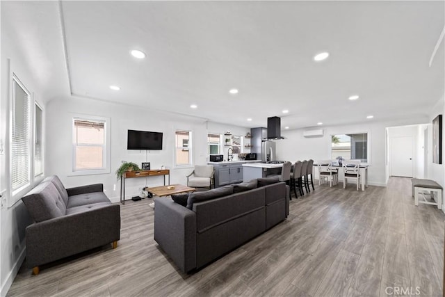 living area featuring a wealth of natural light, baseboards, wood finished floors, and recessed lighting