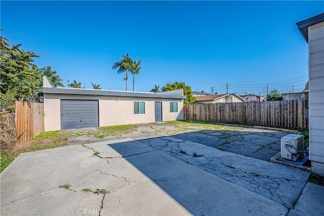 exterior space featuring a garage, a fenced backyard, and driveway