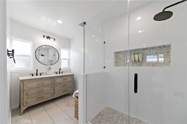 bathroom with a sink, marble finish floor, a shower stall, and double vanity