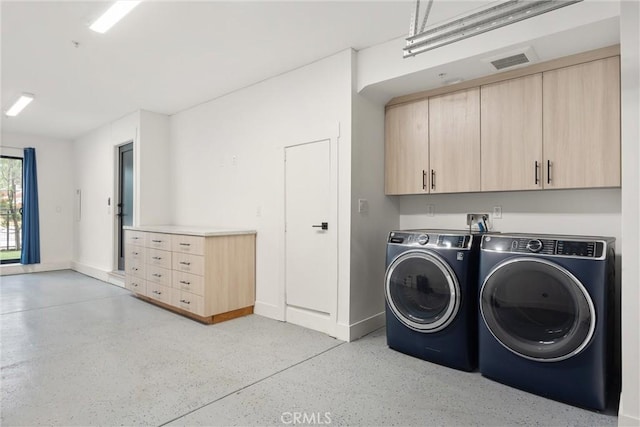 washroom featuring visible vents, cabinet space, separate washer and dryer, and baseboards