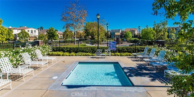 pool with a patio area and fence