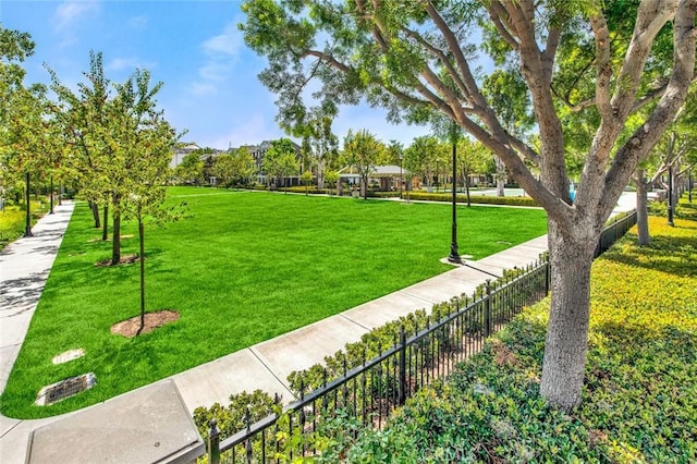 surrounding community with a lawn and fence