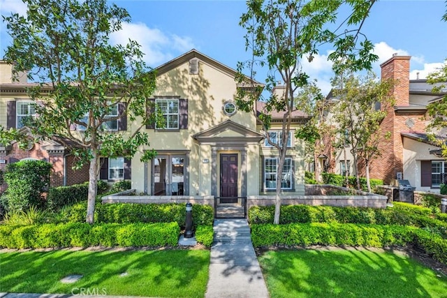 view of front of house featuring stucco siding and a front yard