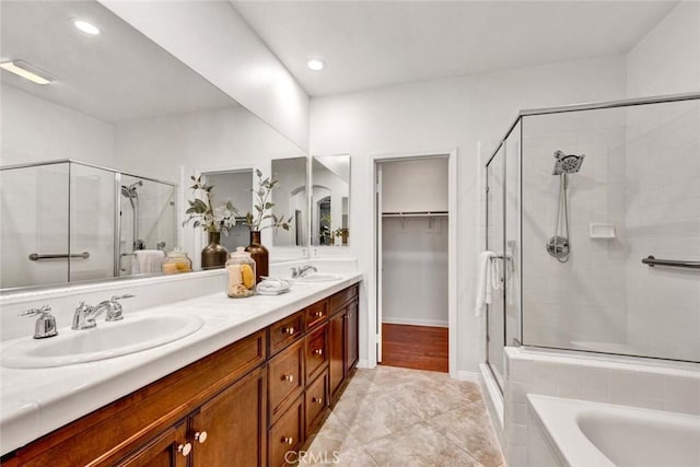 full bath featuring tile patterned floors, double vanity, a stall shower, and a sink