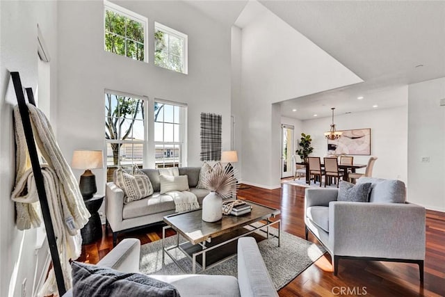 living room with recessed lighting, baseboards, a high ceiling, and wood finished floors