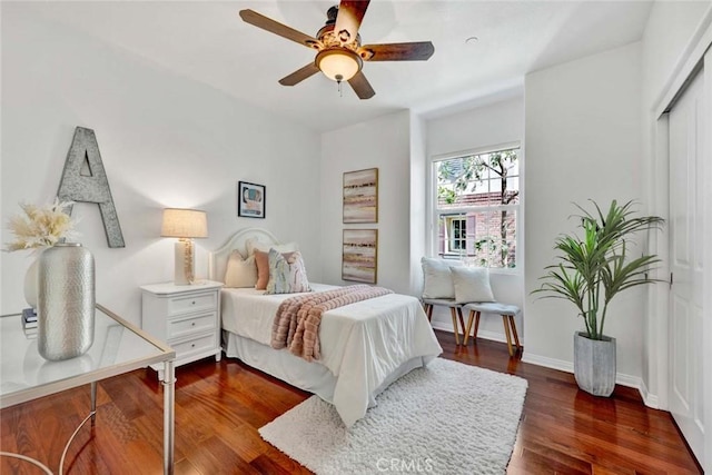 bedroom with baseboards, dark wood-type flooring, and a ceiling fan