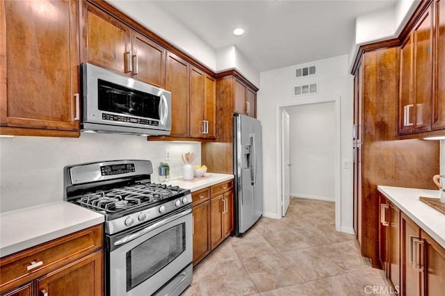 kitchen featuring light countertops, brown cabinetry, and stainless steel appliances