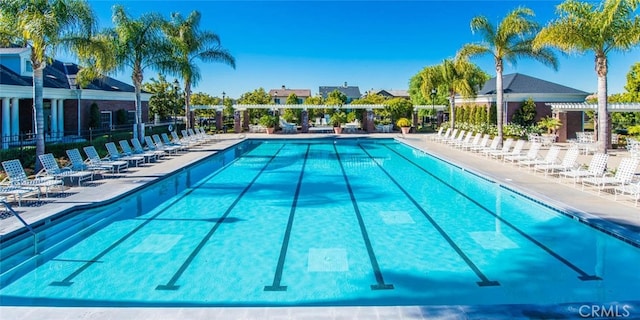 pool with a patio area and fence