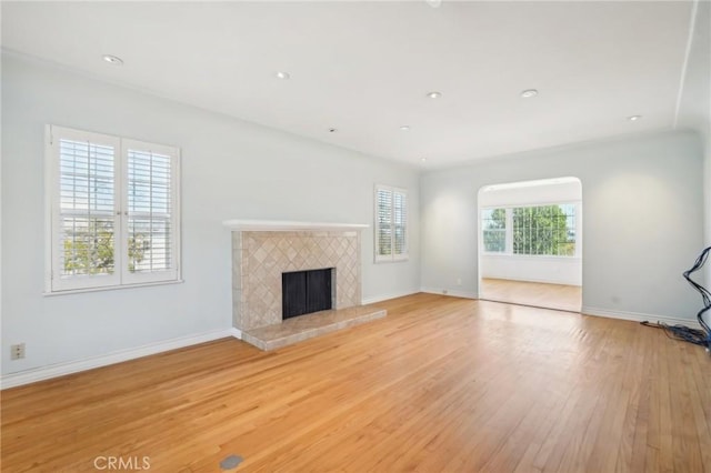 unfurnished living room with baseboards, light wood-style flooring, and a fireplace