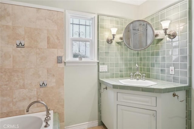 full bath featuring vanity, a bathtub, tasteful backsplash, and baseboards