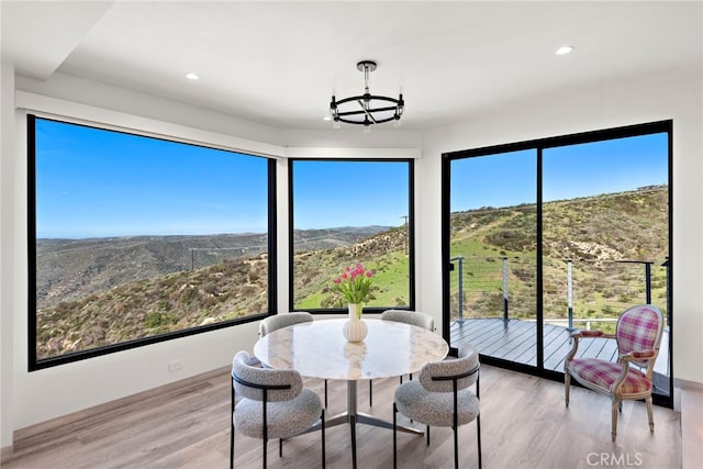 dining area with recessed lighting, an inviting chandelier, and wood finished floors