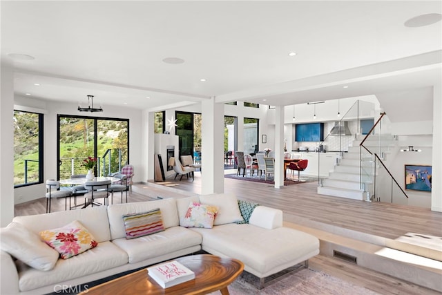 living room with light wood finished floors, stairway, recessed lighting, and visible vents