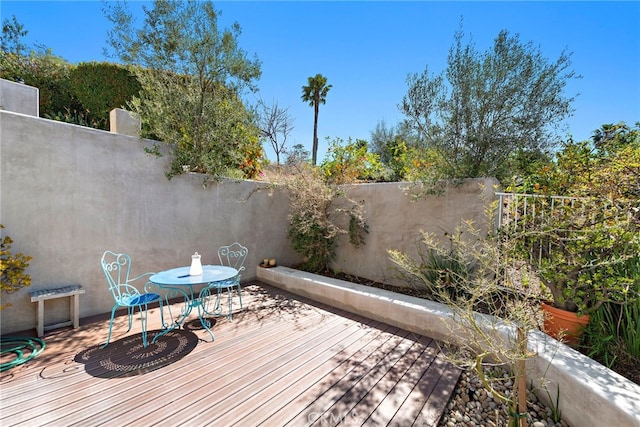 wooden deck with outdoor dining space and fence