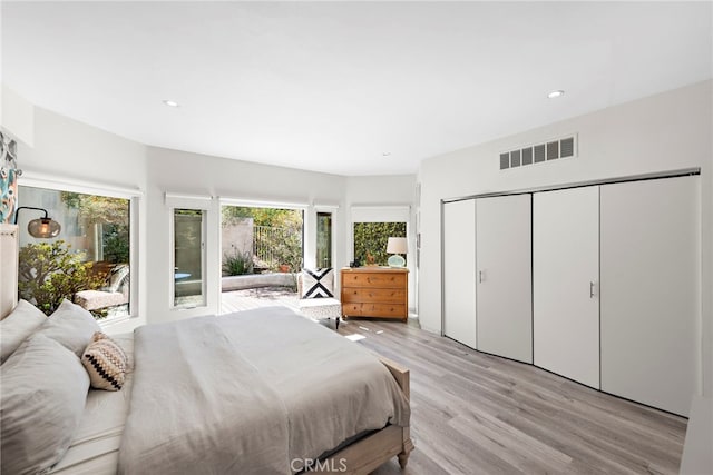 bedroom with recessed lighting, visible vents, a closet, and light wood-style flooring