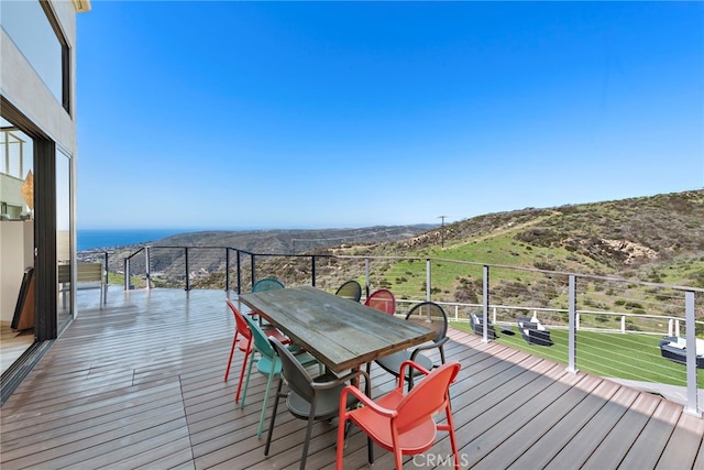 wooden terrace with a mountain view and outdoor dining space