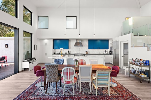 dining room with a high ceiling and light wood finished floors