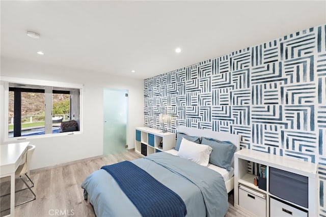 bedroom featuring recessed lighting, wood finished floors, and an accent wall